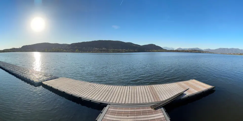 Panorama di un lago con il pontile in una giornata di sole