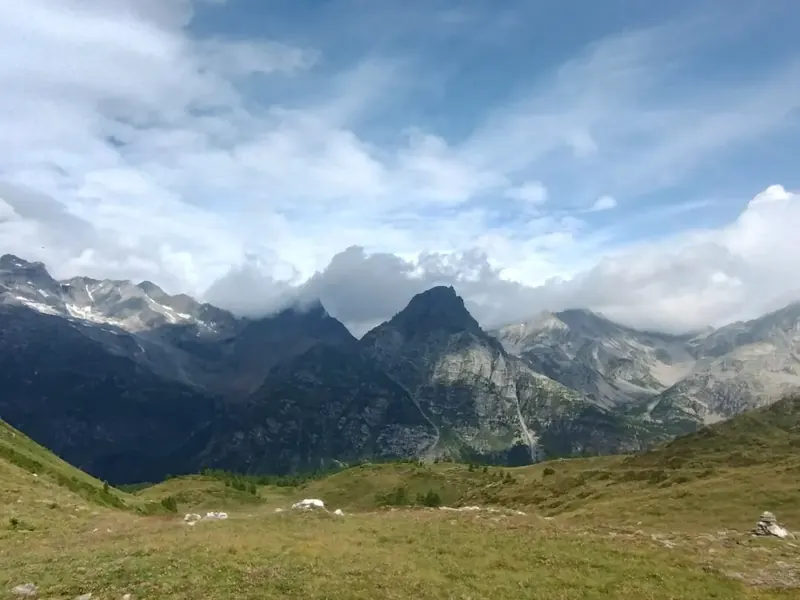 Pascoli in quota e montagne sotto il cielo nuvoloso in Alpe Devero